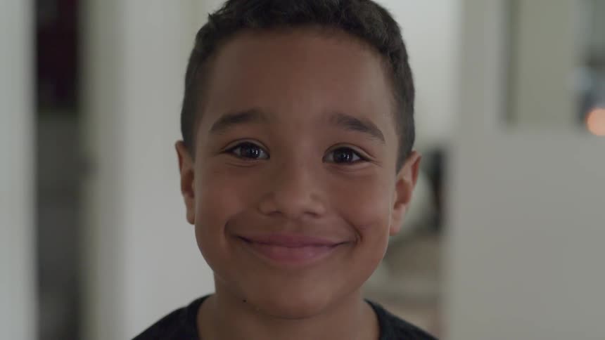 A boy smiles into the camera