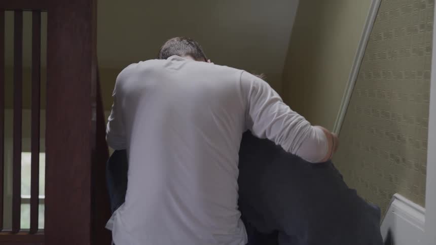 Father is comforting his son while sitting on the stairs