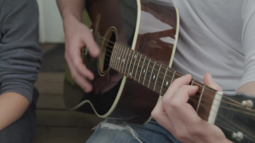 A man playing a acoustic guitar