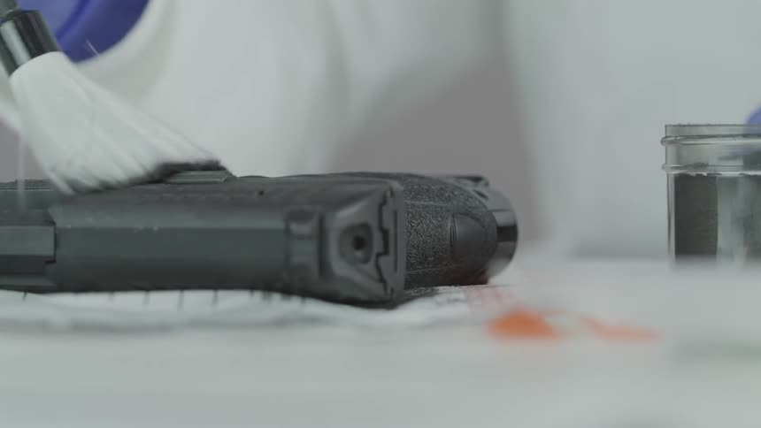 Person wipes a gun with a brush