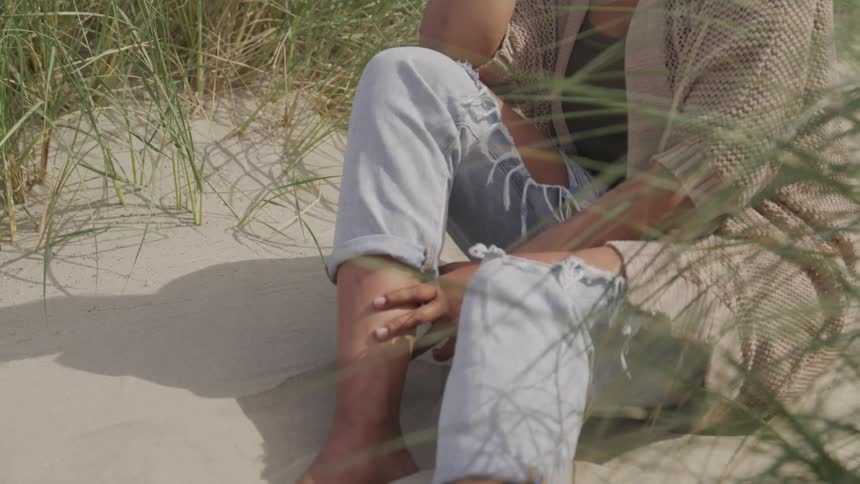 A teenager sits on the beach