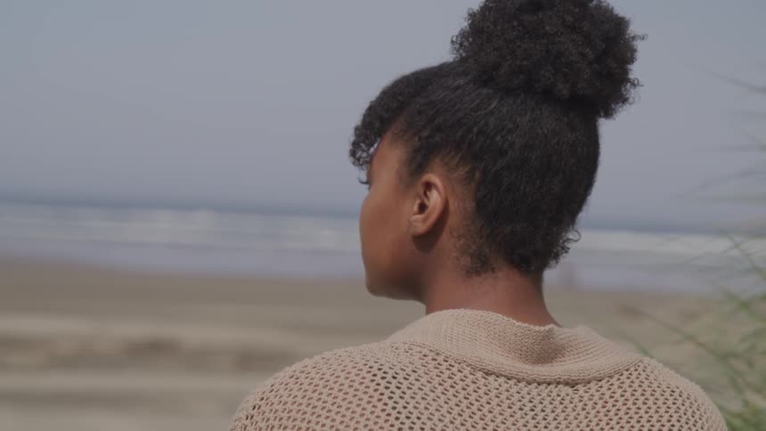 A woman is sitting at the beach