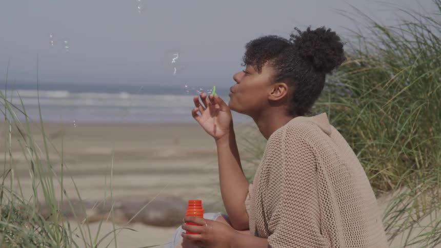 A black female playing with bubbles