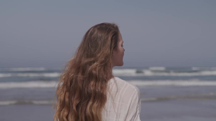 A woman stands on the beach