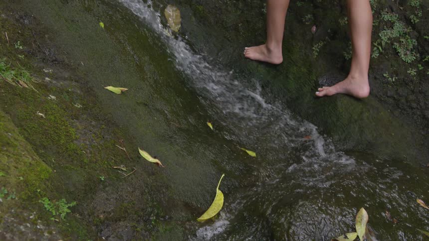 A person is hiking up a hill with water coming down