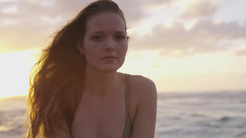 A woman is standing by the ocean