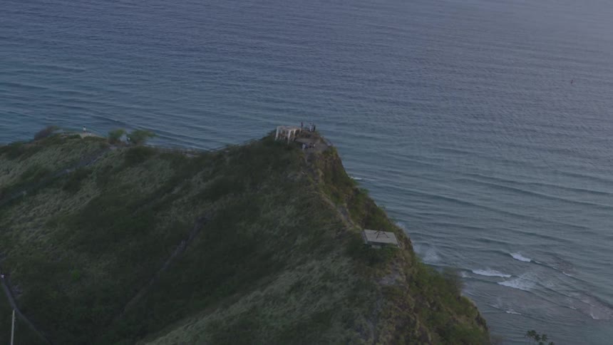 An aerial view of a mountain is next to the ocean