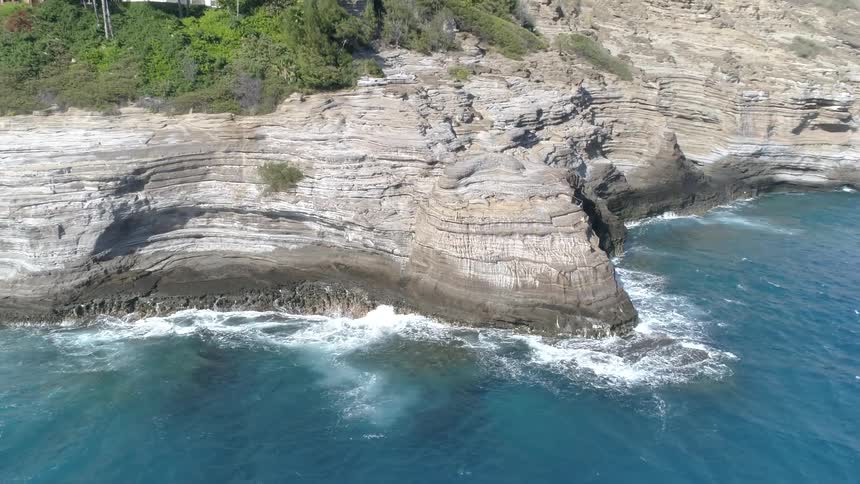 A steep rocky shoreline during the day