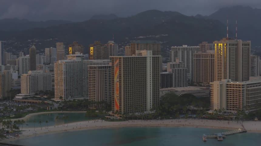 The sun is setting on the city by the mountains