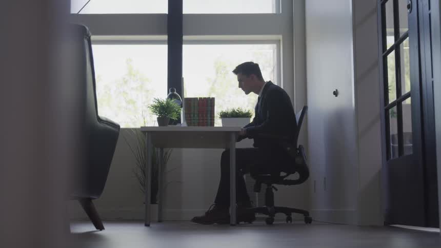 A man is sitting at a desk in the office