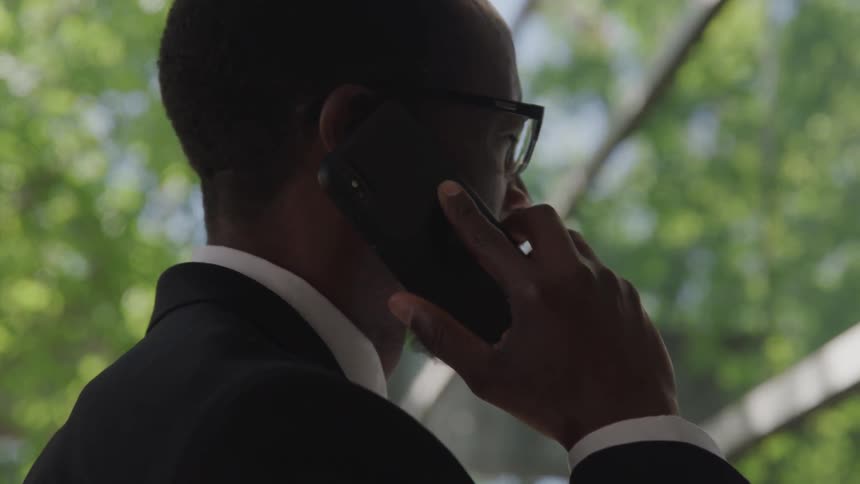 A man is talking on his phone in front of the building