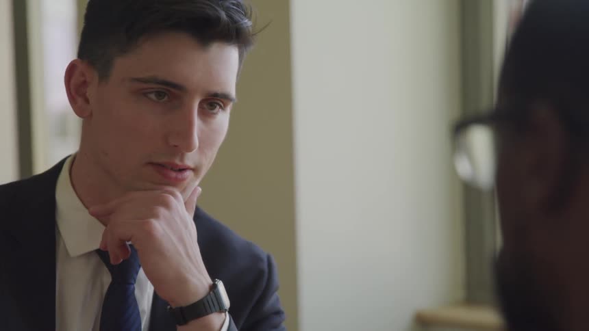 A young man talks to another man