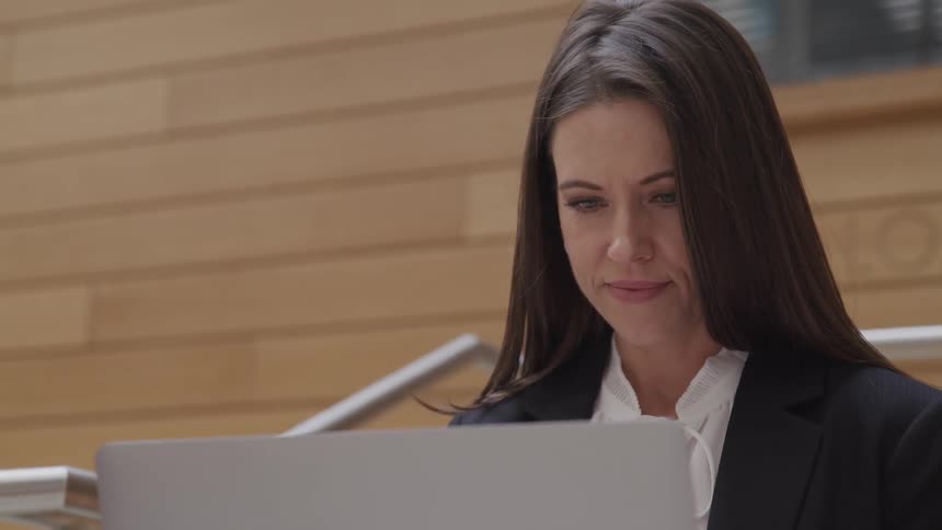 A woman is looking at her laptop