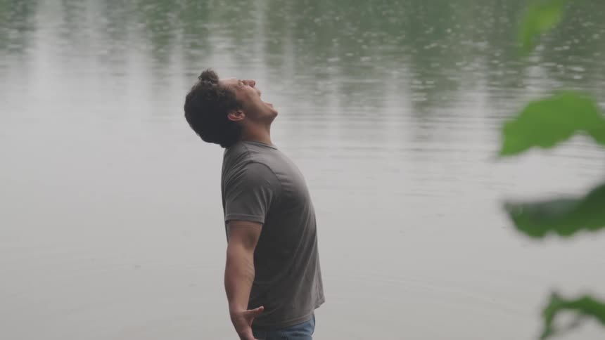 Angry man yelling out while standing in water at a lake