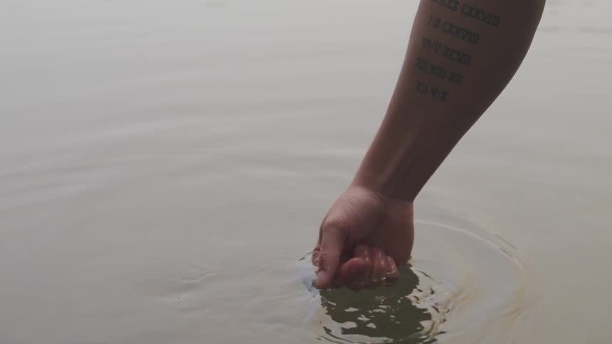 A person is putting their hand in water