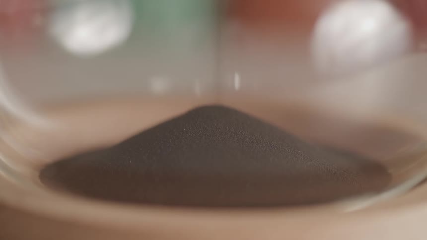 Fine sand collects at the bottom of an hourglass