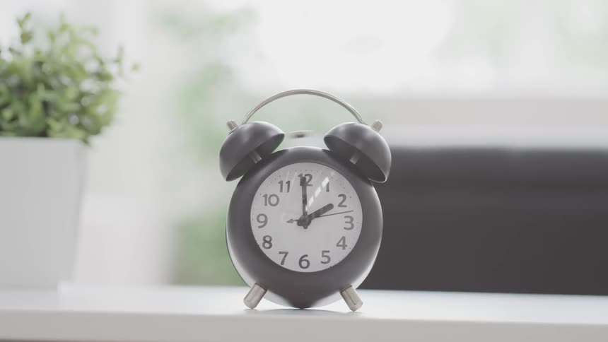 An analog alarm clock is going off
