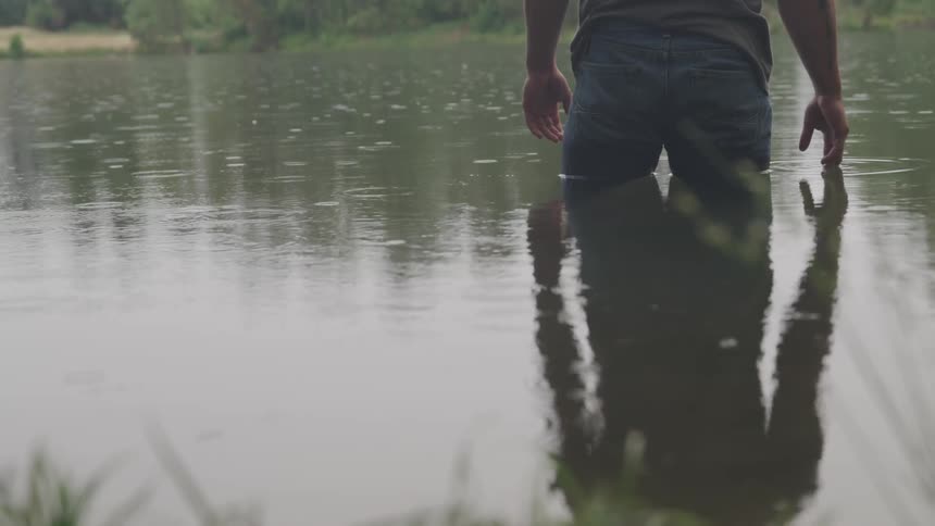 A man standing in a pod during a light rain