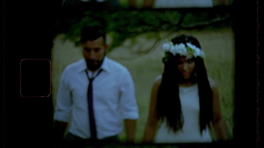 Groom and bride walk on the grass at dusk
