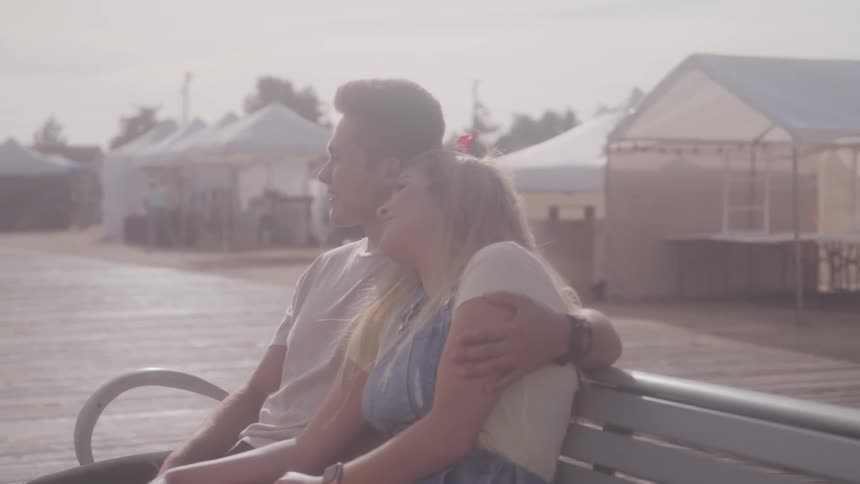 Couple cuddling at the park bench