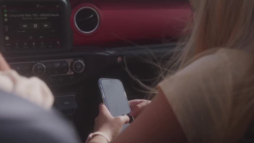 Woman views phone while riding in vehicle passenger seat