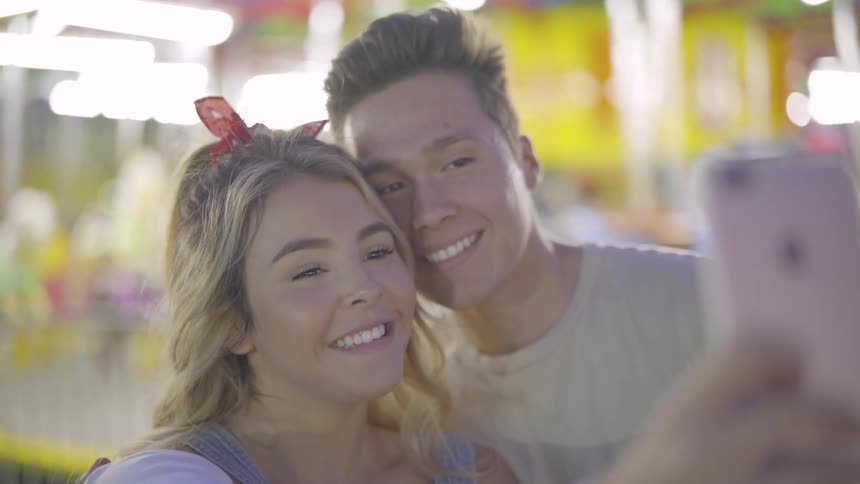 A couple kiss while taking a selfie