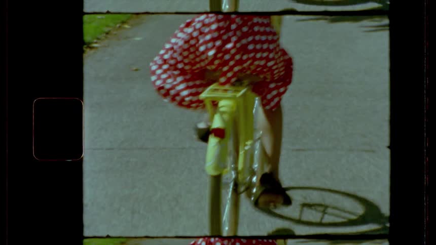 Footage of a woman riding a bike in a neighborhood