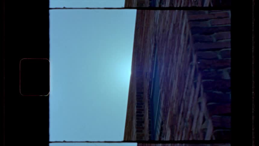 The sun streaming over a tall brick building