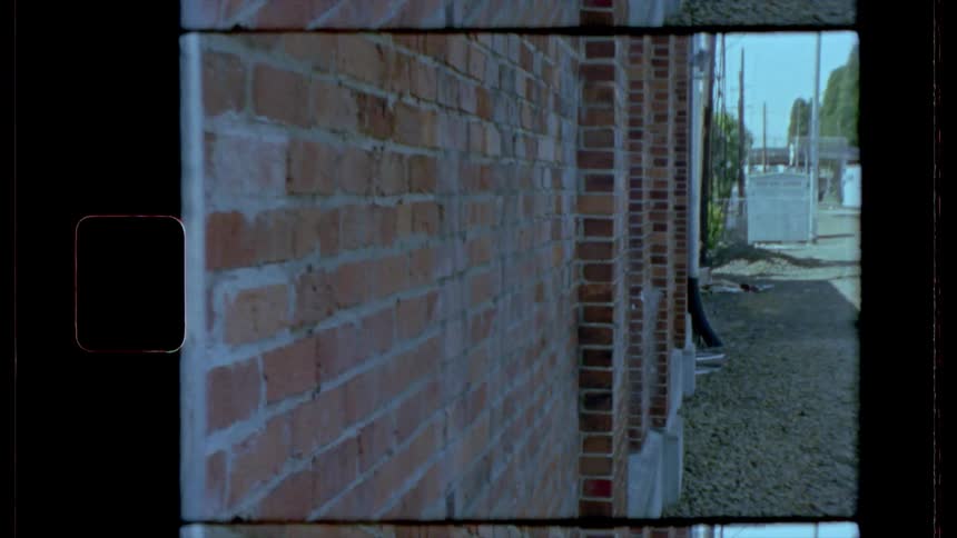 Train tracks run behind brick buildings