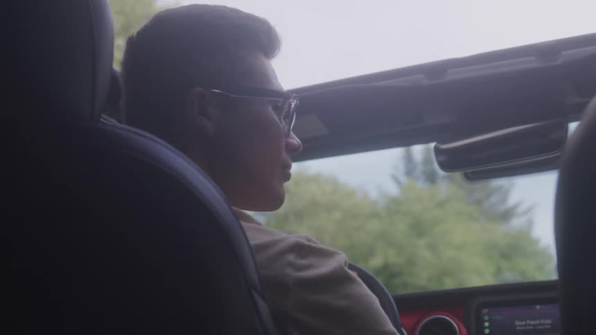 Man with glasses driving car
