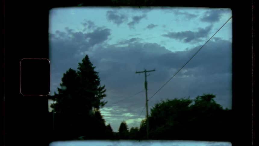 A vehicle drives down a tree lined road