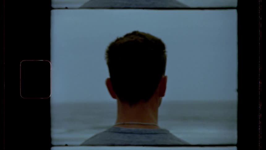 Film footage of a young man looking out at the water