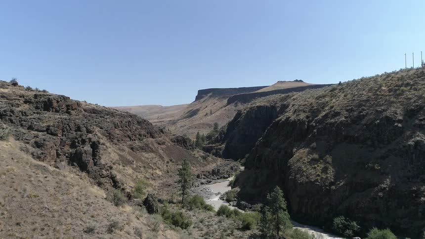 An aerial scenery of a river near cliff and mountain