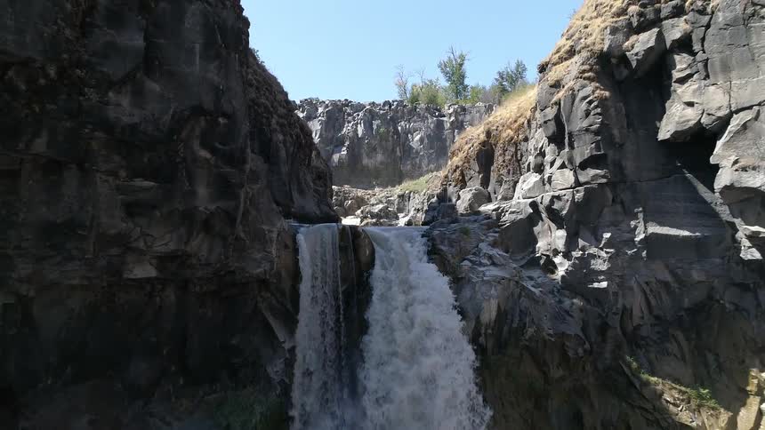 The stream pours into the waterfall on the cliff