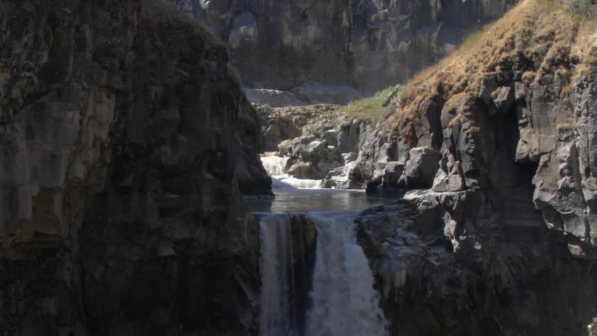 A scenery of a waterfall on the rocky mountain