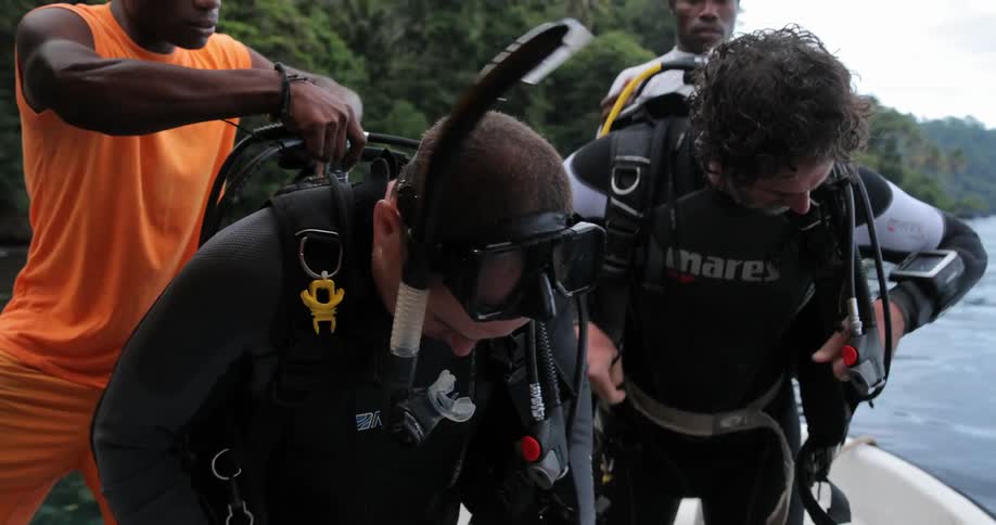 People are putting on scuba diving equipment on a boat
