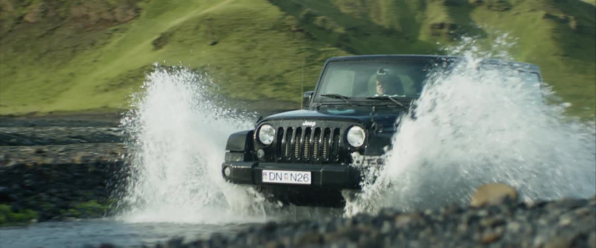 A jeep car driving trough the river