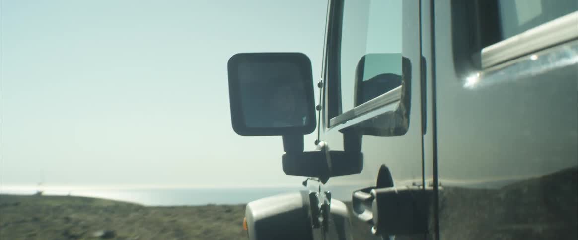 A vehicle driving on a cliff close to the ocean