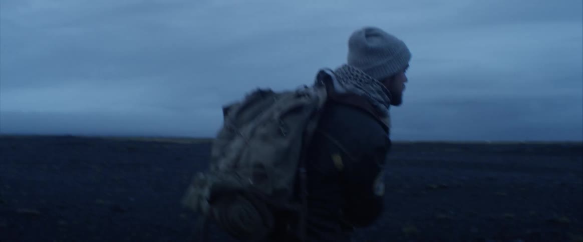 A man is carrying a backpack and hiking outdoors