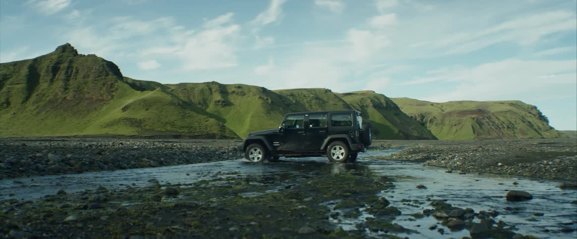 A car is driving through a puddle outdoors