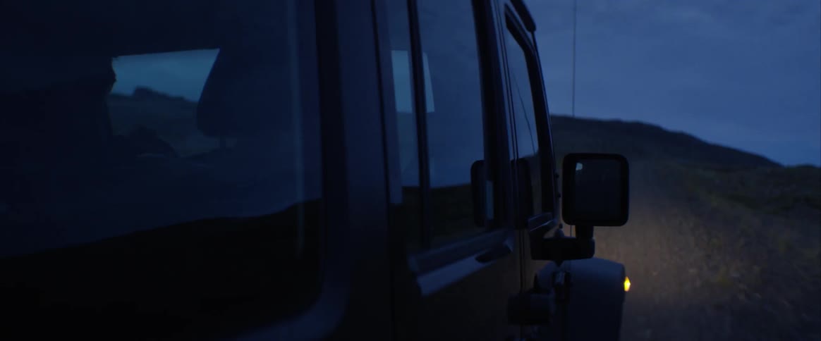 A car is driving outdoors at night