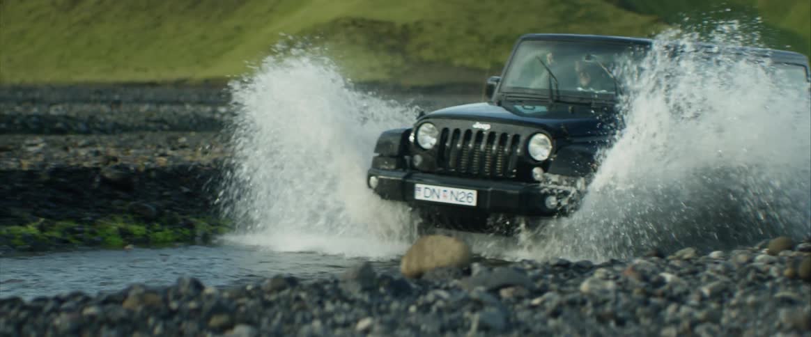 A scenery of a jeep car drive trough the river