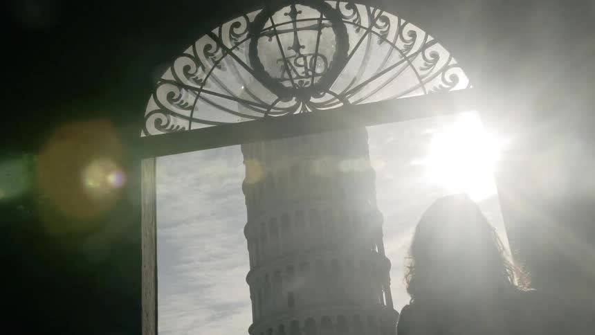 A woman walks outside and looks at a tower