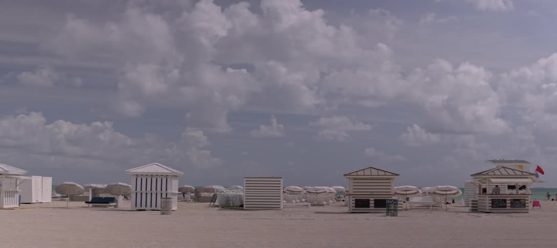 Beach chairs umbrellas as man cycles by