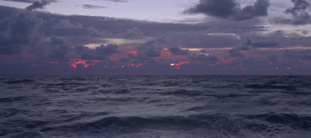 The ocean with waves with the sky and clouds in the background