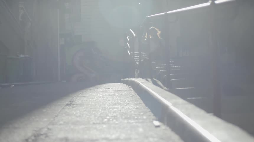 A young girl sits down on some steps outside