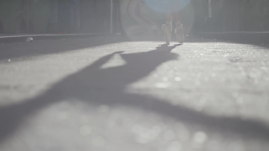 Ballerina dancing on point casts a long shadow