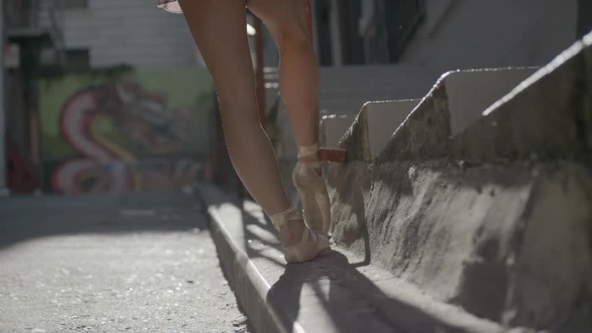 A ballerina stretches outside
