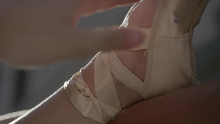 Ballerina does a leg stretch before performing ballet outdoors