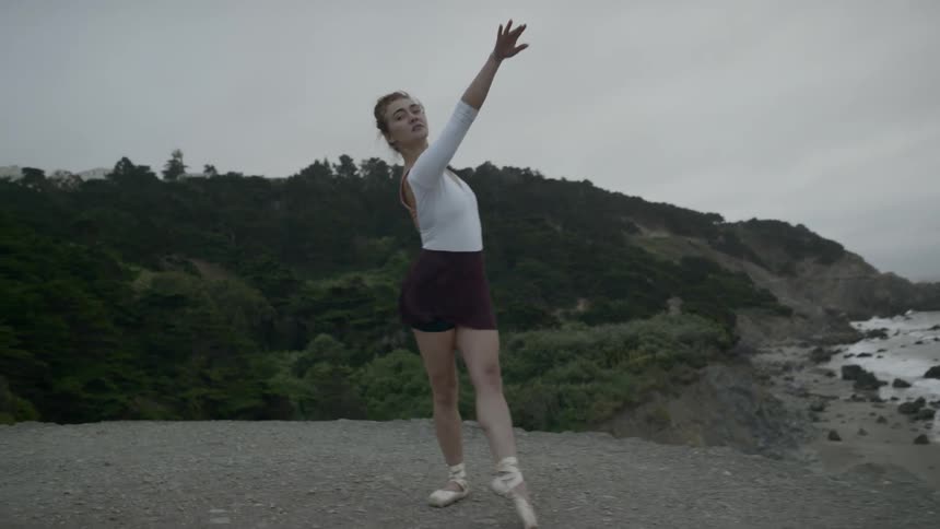 A ballerina dances on the shoreline